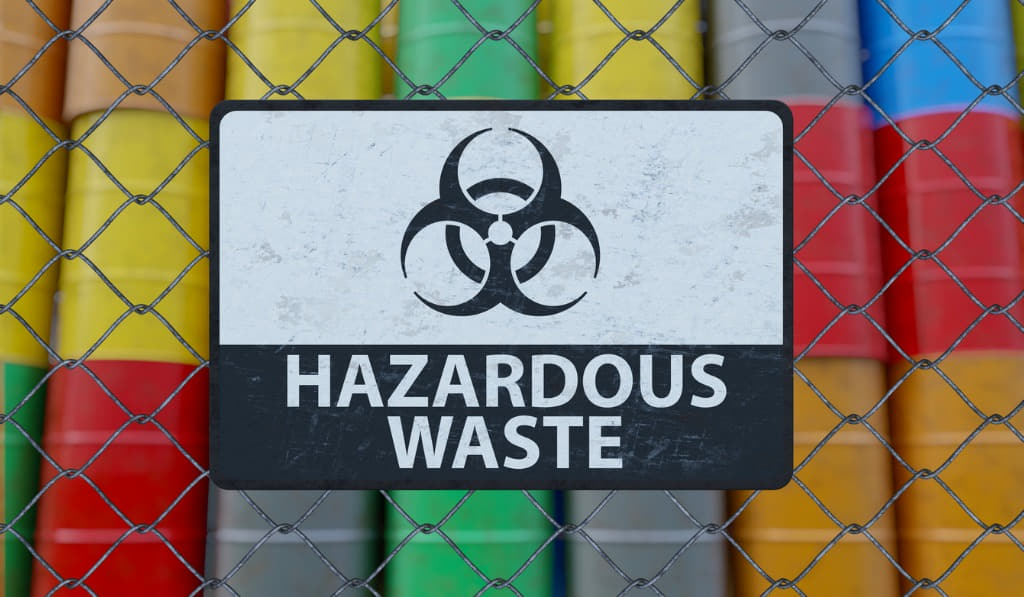 hazardous waste sign with colored barrels containing hazardous waste