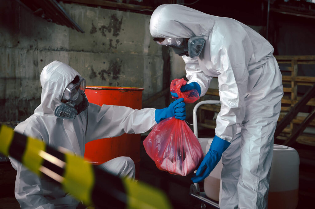 Two workers handling hazardous waste